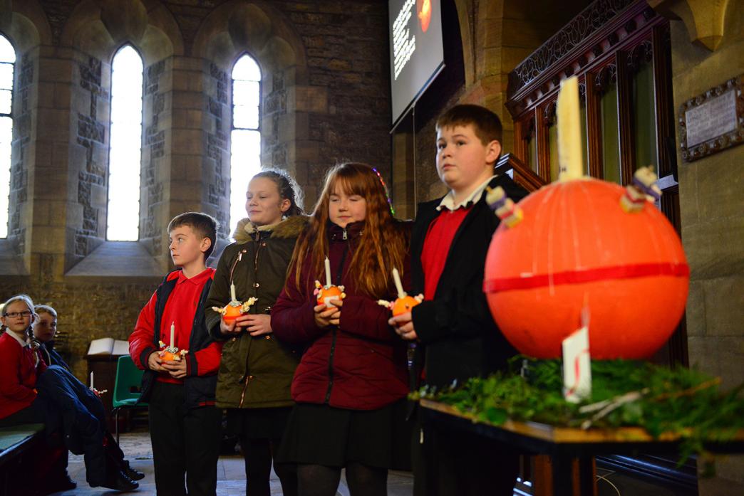 Bailey Bennett, Kate Davidson, Ruby Jones and Adam Tyson wait eagerly for the large Christingle to be lit at St Mary's Church, in Cockfield