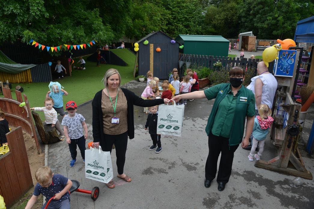 COMMUNITY GIFT: Green Lane Nursery’s business manager Jemma Fletcher receives goodies from Morrisons’ community champion Gillian Robinson. Below, children enjoy water fun