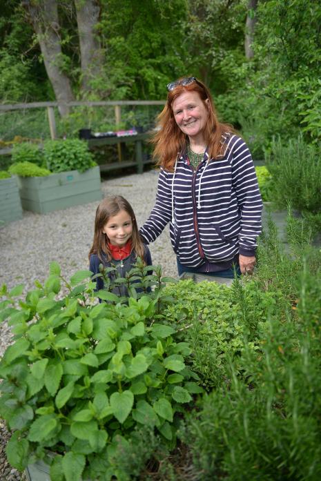 GREEN FINGERS: Little Eire Bradley and gardening enthusiast Suzanne Thomas at one of the raised herb beds at The Hub’s fruit and vegetable garden TM pic