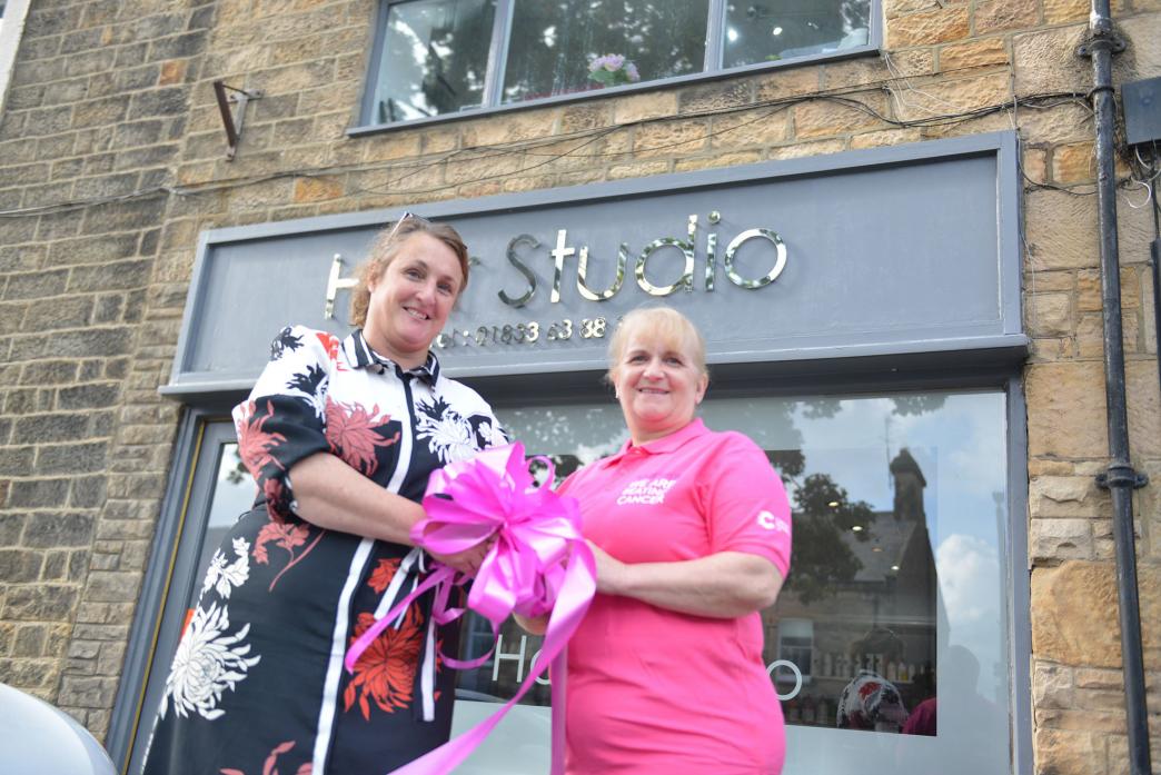 IN THE PINK: Florist Sarah Meeson hands over a pink ribbon to Cancer Research UK fundraiser and hairdresser Sue Birdsall in preparation for the start of the Turn Barney Pink week next month