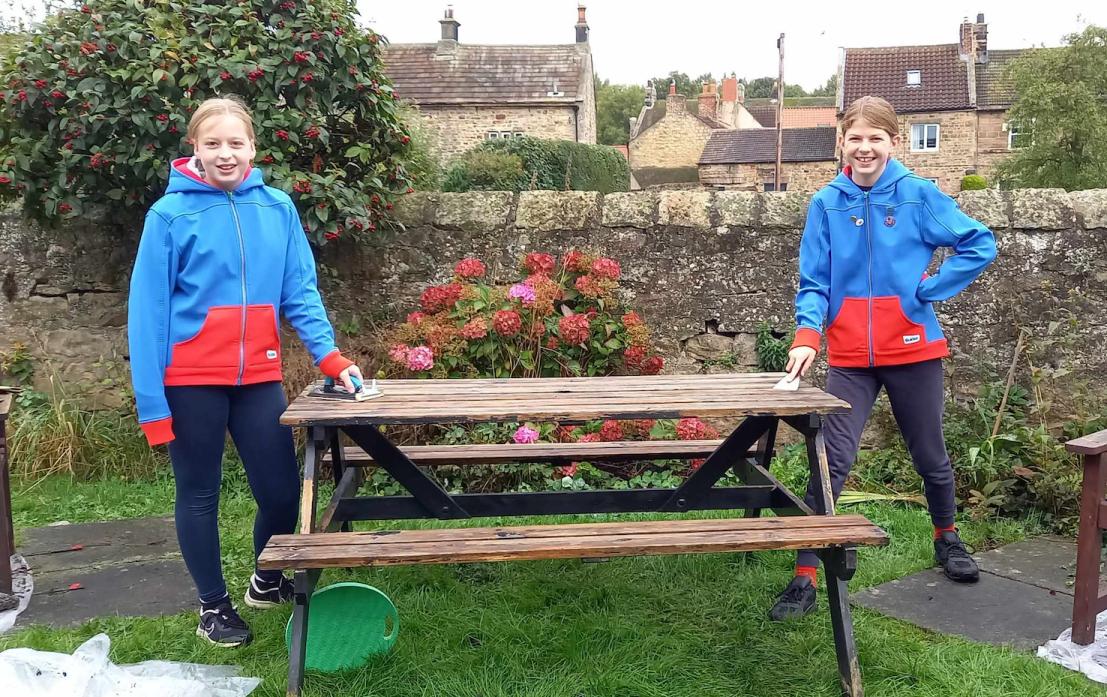 BEFORE: Guides Emily and Millie get to work on the picnic table which needed a bit of TLC to bring it back to its best