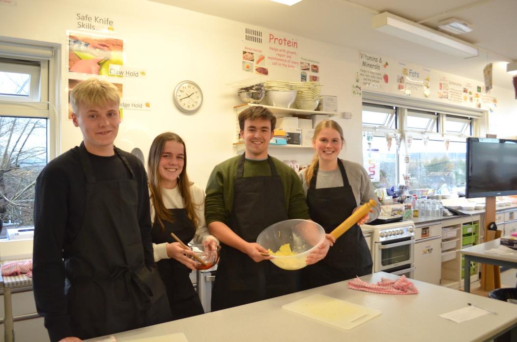 READY, STEADY, COOK: James Cuthbert, Grace Perkins, Ryan Adams and Evie Arundel get busy in the kitchen ahead of this year’s pop-up pizza night, which will raise money to support research into the form of breast cancer which teacher Katie Swinburne has be