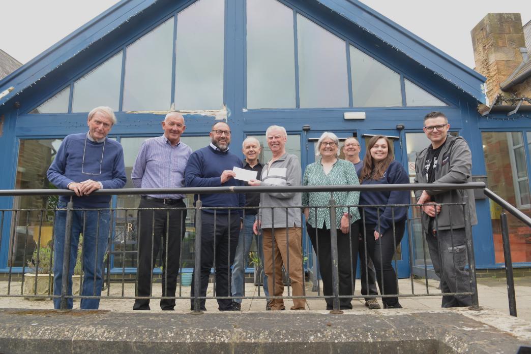 HISTORY CASH: Carl Brabban of CA Group hands Brian Carter, treasurer of Evenwood Ramshaw and District History Society a £600 cheque. Looking on are Robert Linsley, Stuart McConnell, Graeme Lamb,  Jackie Dodds, Kevin Richardson, Roselle Cox and John Bogle