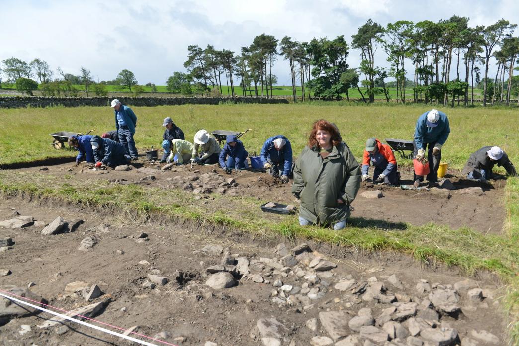 HISTORY EXCAVATION: PhD student Beverley Still examines some burned stones in a trench, while fellow students and members of Altogether Archaeology continue digging a second trench