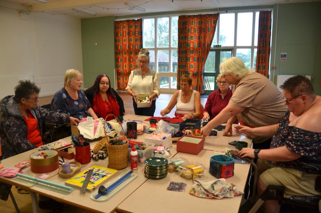 SUPER STITCHERS: Andrea Hobbs, standing centre, offers a few tips to those who came along for the Sisters in Stitch session TM pic