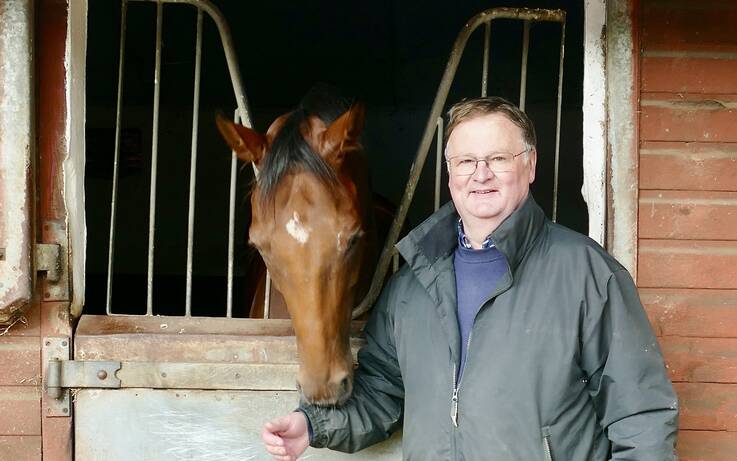 Trainer opens the stable door to show a thoroughbred level of care