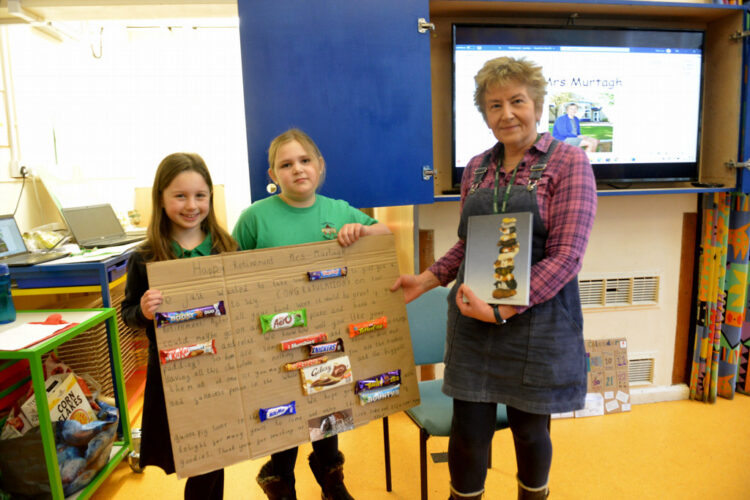 FOND FAREWELL: Holly and Isla present Carolyn Murtagh with a special message made using popular chocolate bars