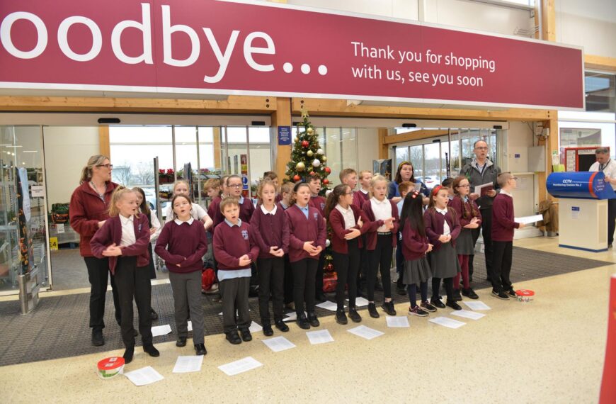 Pupils serenade shoppers while raising…